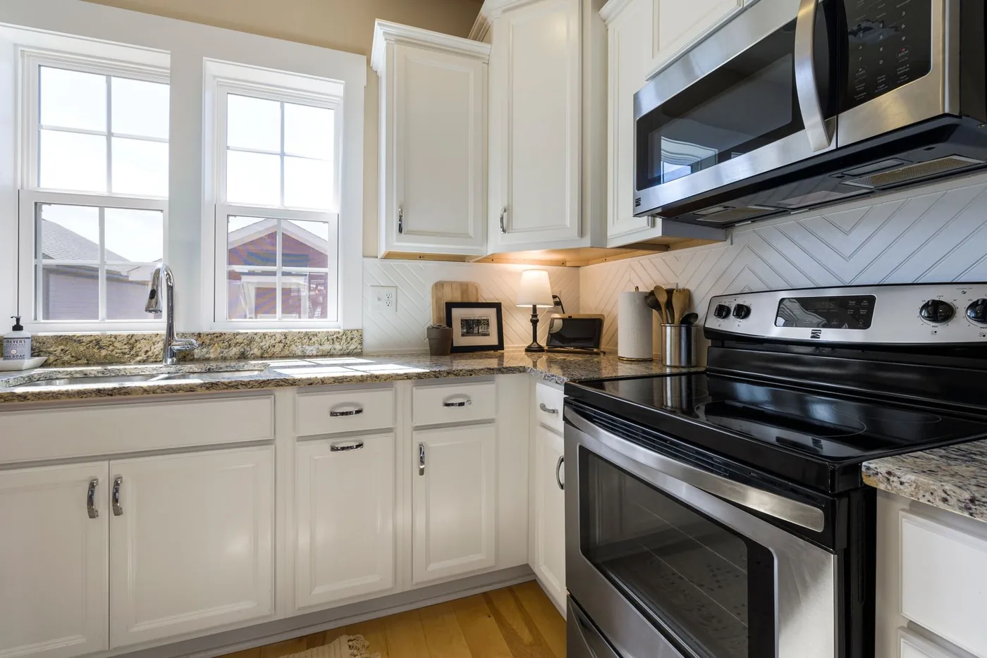 Bright kitchen with freshly refinished white cabinet doors and clean counters
