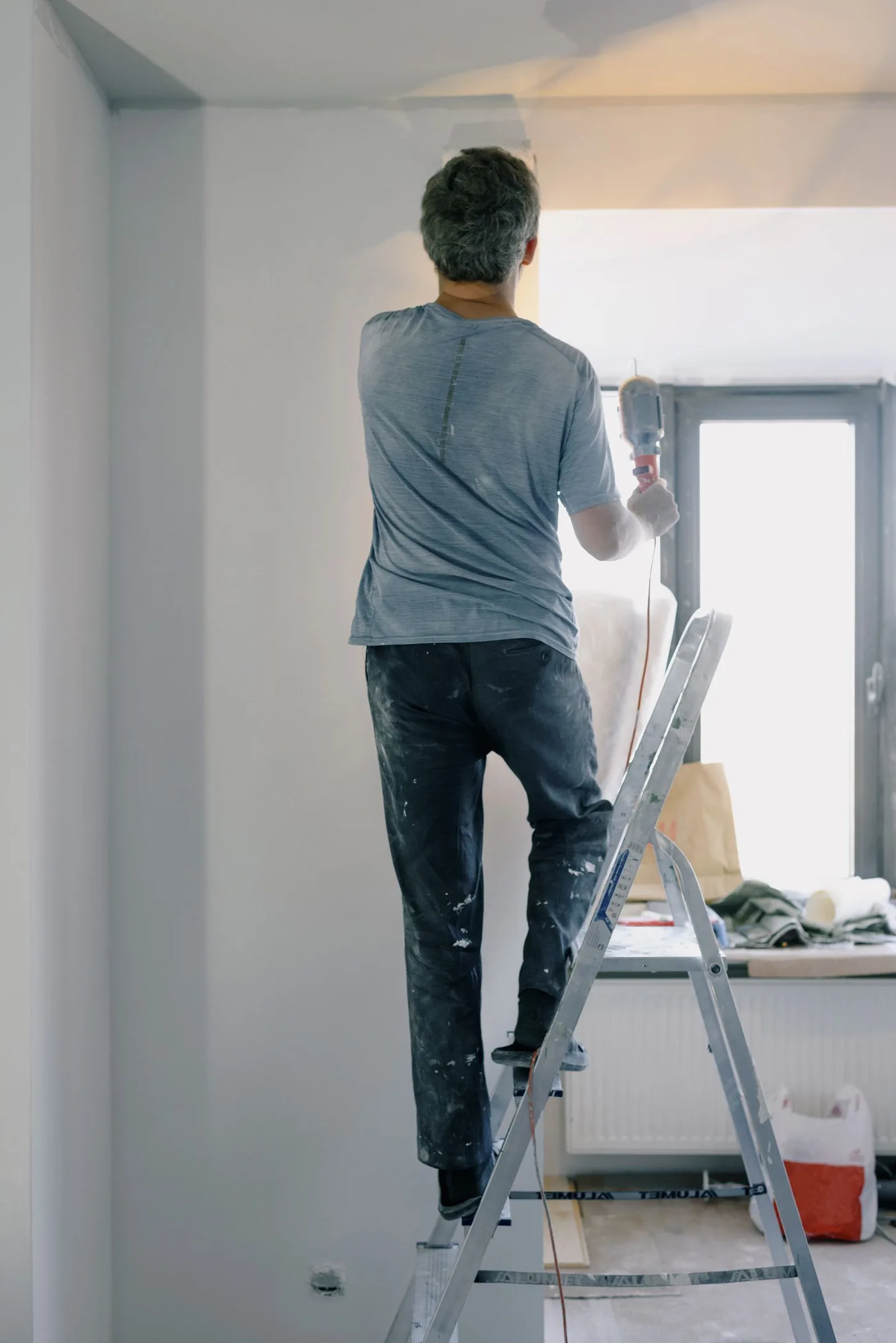 Repair technician on a ladder working through a home repair task list