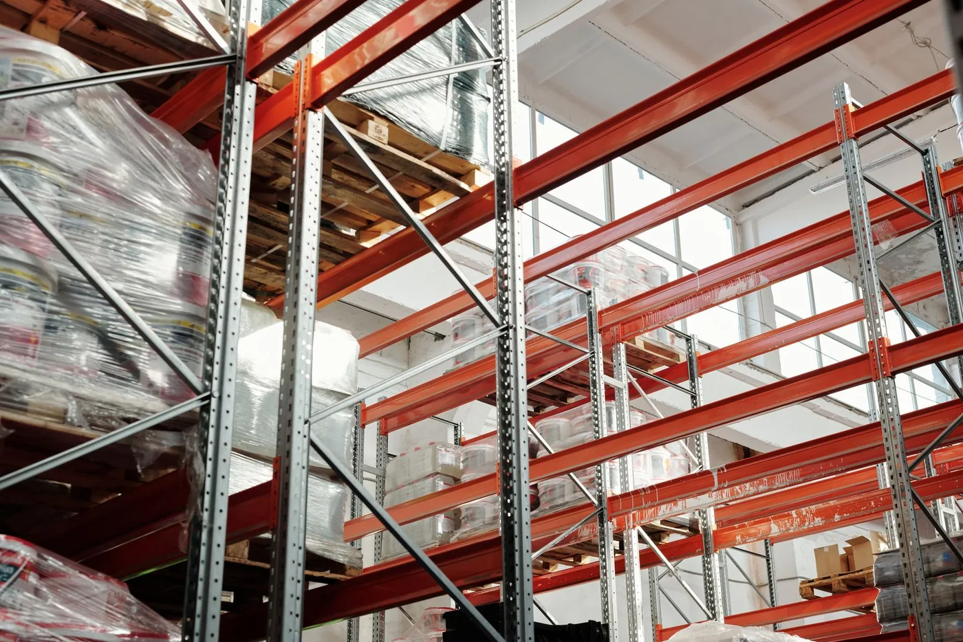 Bright organized warehouse aisle with pallets and tall storage racks